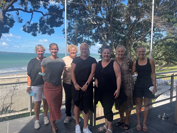 Group of managers standing together with the coast in the background